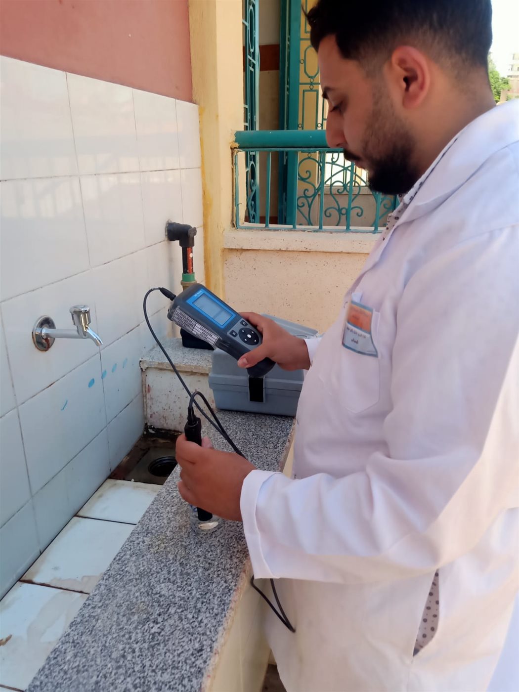 أحد أفراد شركة مياه سوهاج أثناء قياس كفاءة المياه