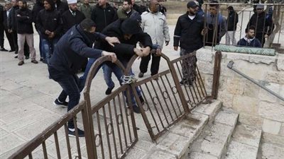 عشرات الفلسطينيين يحطمون البوابة الحديدية بالمسجد الأقصى
