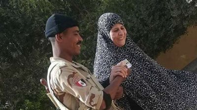 مجند يساعد مسنة للإدلاء بصوتها في مدرسة عزبة الوالدة بحلوان