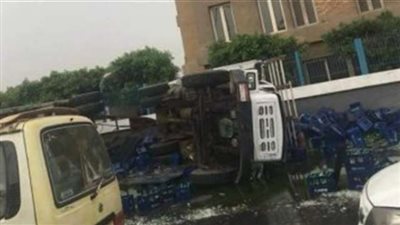 انقلاب سيارة نقل محملة بزجاجات مواد غازية بالأوتوستراد