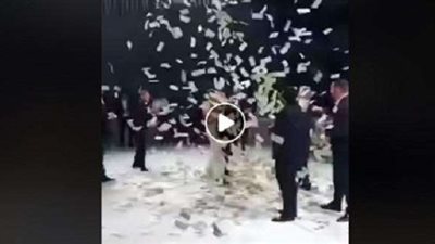 عروسان يرقصان تحت أمطار من النقود.. (فيديو)