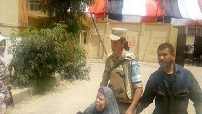 رجال الجيش يساعدون مُسنة للإدلاء بصوتها بمدرسة صفية زغلول في مدينة نصر