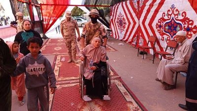 مُجند يساعد مُسنة للإدلاء بصوتها بـ 