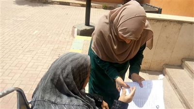 بالصور.. رئيس لجنة صفية زغلول يخرج لمُسنة خارج اللجنة للإدلاء بصوتها