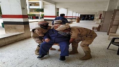 رجال الجيش يحملون عجوزًا للإدلاء بصوته في استفتاء الدستور بكوبري القبة