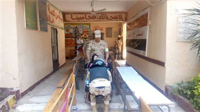 بالصور.. رجال الجيش والشرطة يساعدون مسنة للإدلاء بصوتها في مدينة نصر
