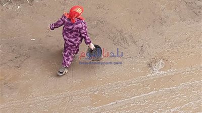 تبلغ من العمر 51 عاما.. سيدة ترفع المياة بالطريق العام تيسيرًا على المواطنين بالمنيا