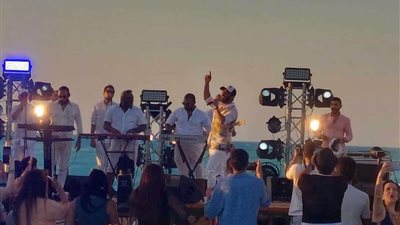 تامر حسني يداعب أحد أعضاء فرقته: هات الطاقية الشمس جاية عليا