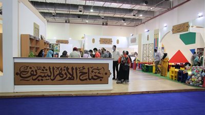 رواد معرض الإسكندرية للكتاب يلتقطون صورا تذكارية مع صورتي الرئيس السيسي وشيخ الأزهر