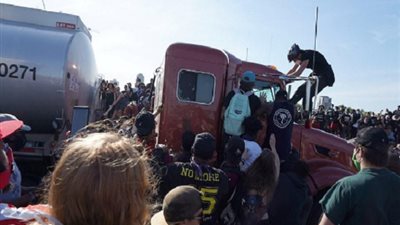شاحنة كبيرة تُحاول فض حشد من المتظاهرين بأمريكا والمحتجون يحاولون اعتراضها