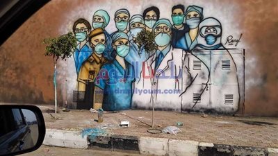 طالب يرسم جرافيتي لدعم الفرق الطبية على واجهة مستشفى صدر المحلة