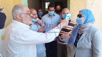 بدون كمامة.. موظف يجري الكشف على وكيل تعليم بني سويف 