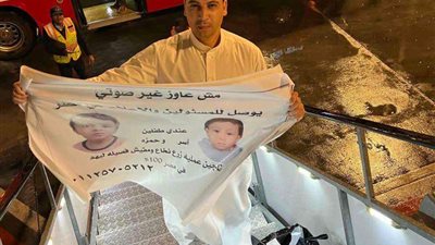 من داخل الطائرة..  والد آسر وحمزة يحمل لافته «عندي طفلين محتاجين عملية زرع نخاع»