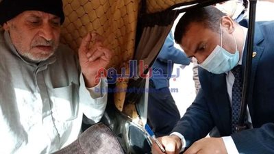 رئيس لجنة بالمحلة يساعد رجل مسن للأدلاء بصوته فى جولة الإعادة