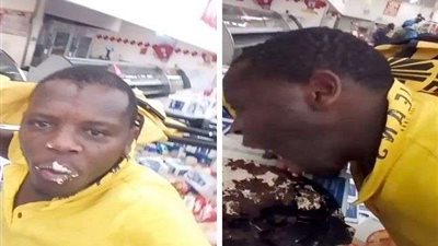 صورة لمواطن جنوب إفريقي يأكل  بشراهة أثناء سرقة المحال والمراكز التجارية ببلاده